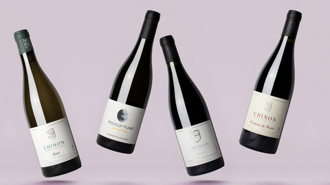 Four bottles of Chinon wine on a light purple background