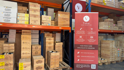 Storage warehouse with stacked wooden boxes and a Vintage signboard.